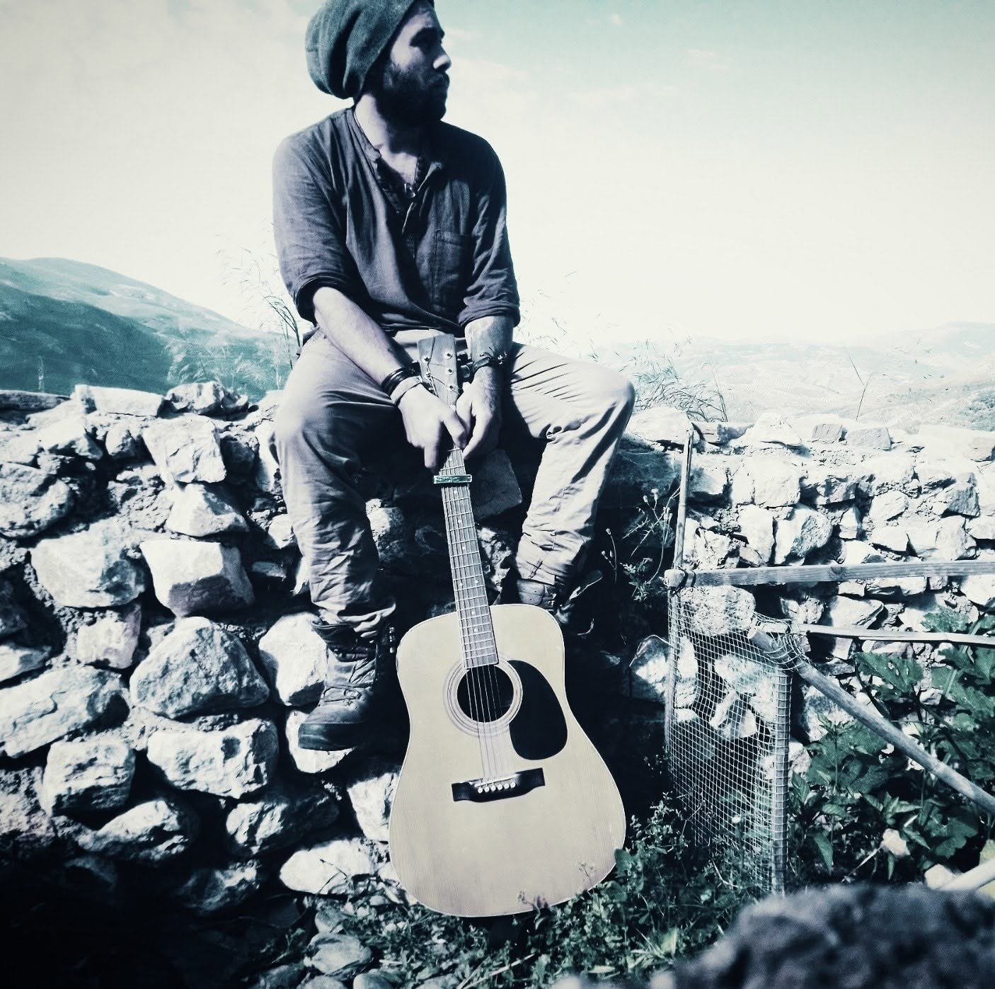 Roman with an acoustic guitar outdoors